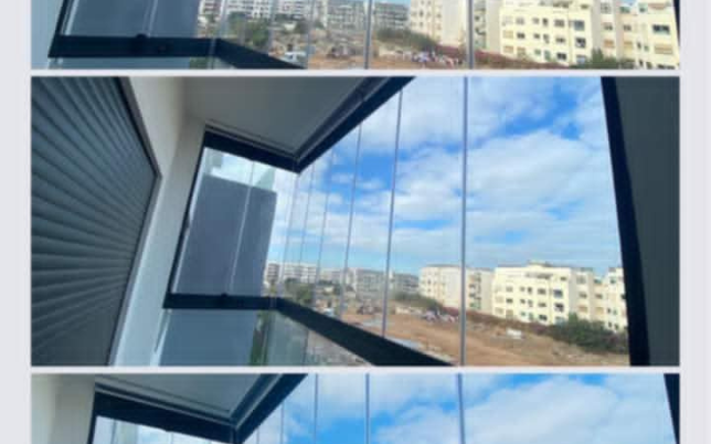 زجاجي شفاف يطل على شرفة مغطاة، مع إطار من الألومنيوم.